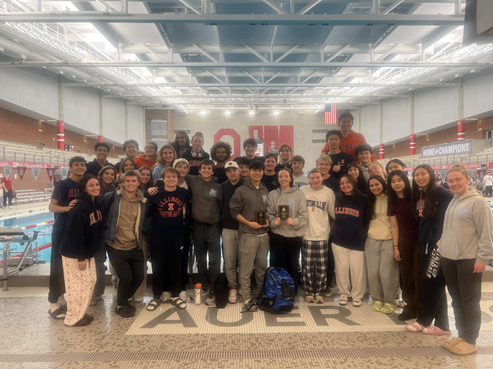 Illini Swim Club at a meet at Ohio State Univeristy. The team stands in front of the pool.