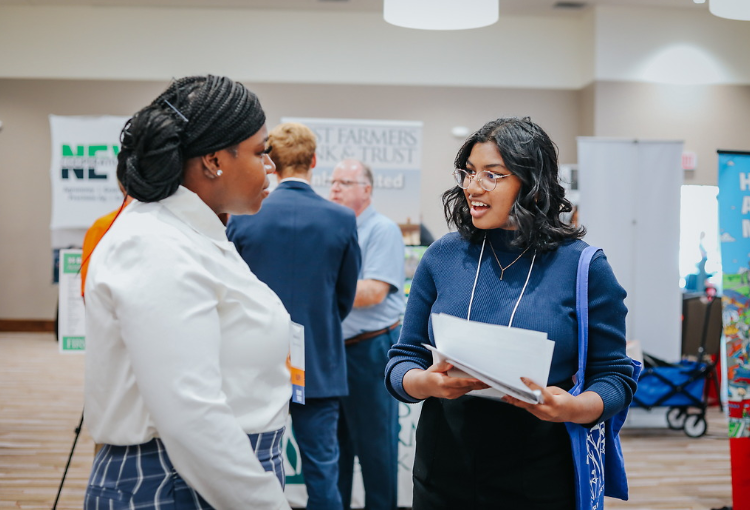 Student at fair speaking with recruiter. 
