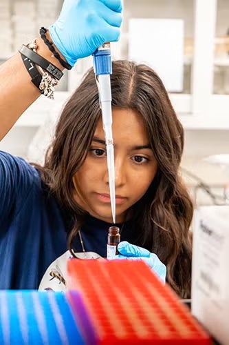 Student in a lab pipetting