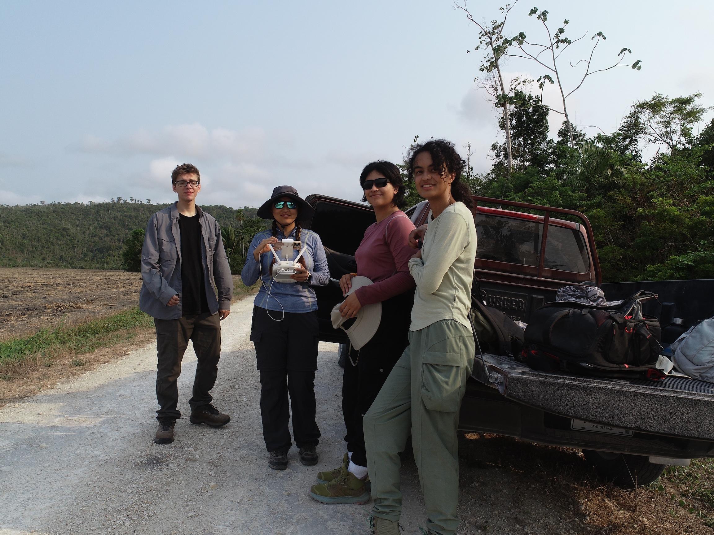 Yifan and a group of students standing by a truck during fieldwork