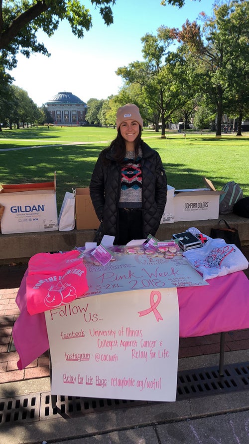 Allison Garetto standing behind a fundraising table on the Quad