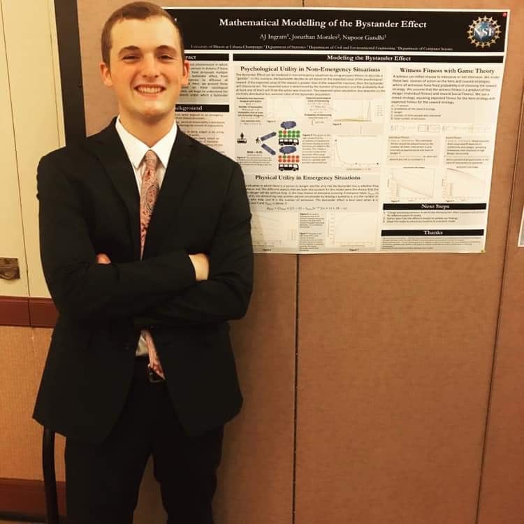 AJ Ingram poses in front of a research poster.