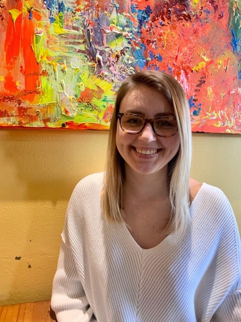 LAS student Angie Orzel poses for photo in front of a colorful background