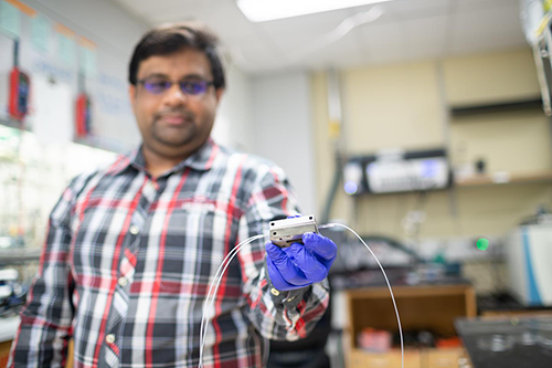 Chemical and biomolecular engineering graduate student Saket Bhargava holds a flow electrolysis cell