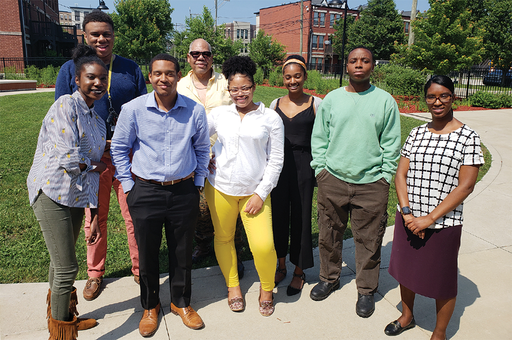 William Conwill, center, a professor in the Department of African American Studies, poses with Illinois students for a photo near Chicago's Oakwood Community Center