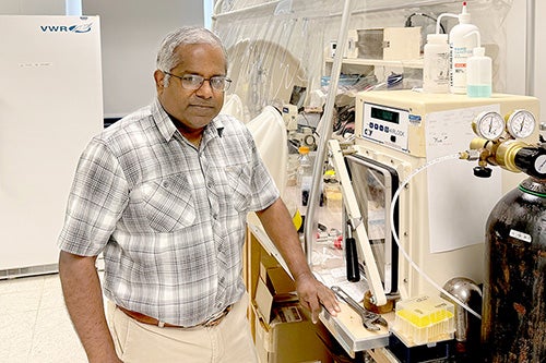 Satish Nair standing in his laboratory