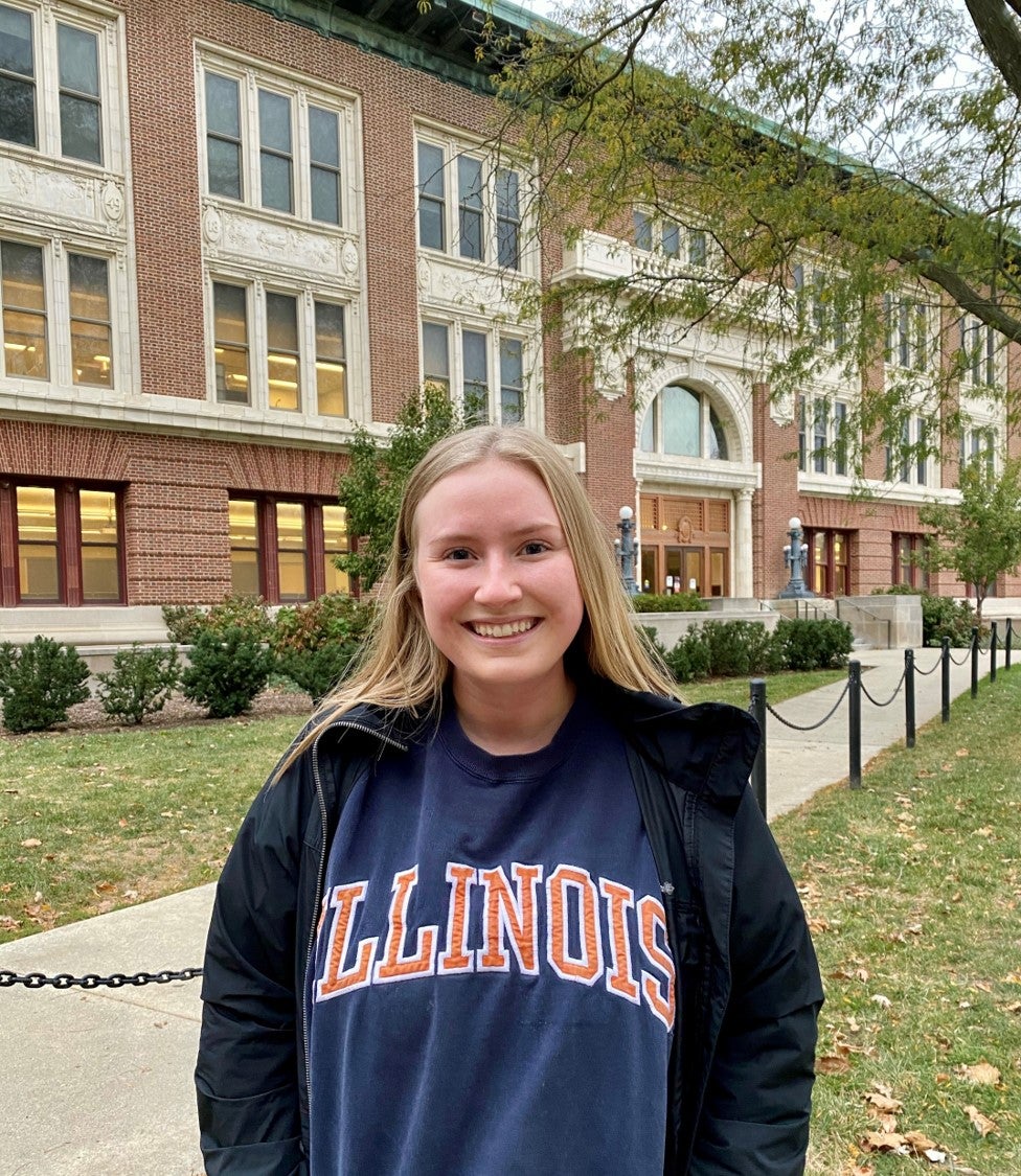 LAS student poses for photo in front of Lincoln Hall in an Illinois sweatshirt
