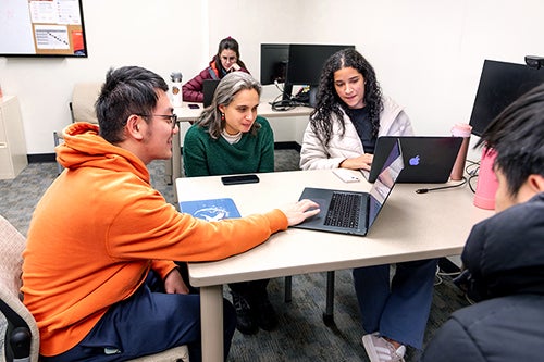 Students and professor working at table