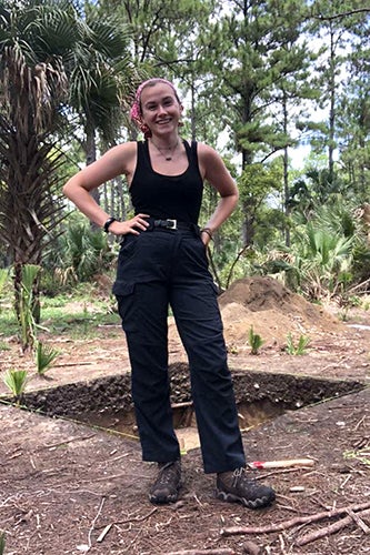 Rachel Burdette stands outside a small archaeology pit during a dig in Georgia