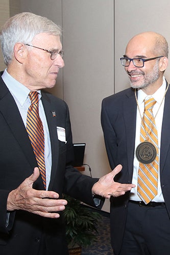 Christopher Rao, right, speaks with alumnus Ray Mentzer 