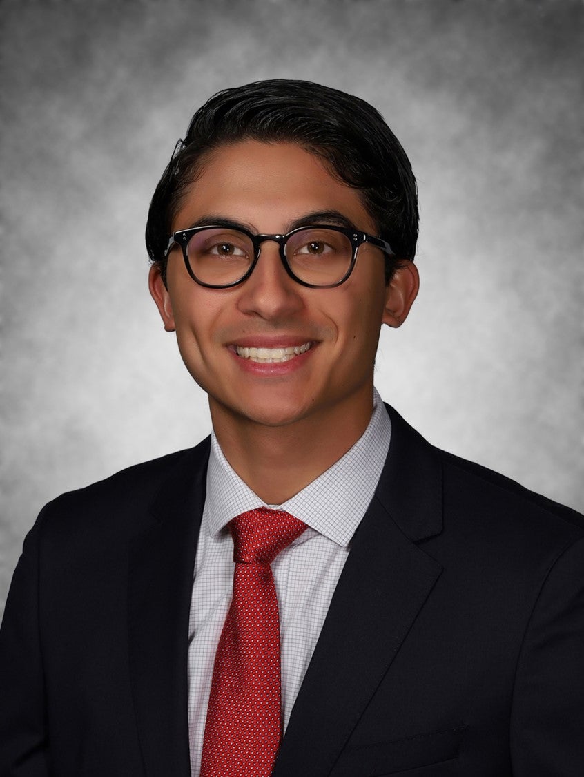 Student poses for photo in black suit