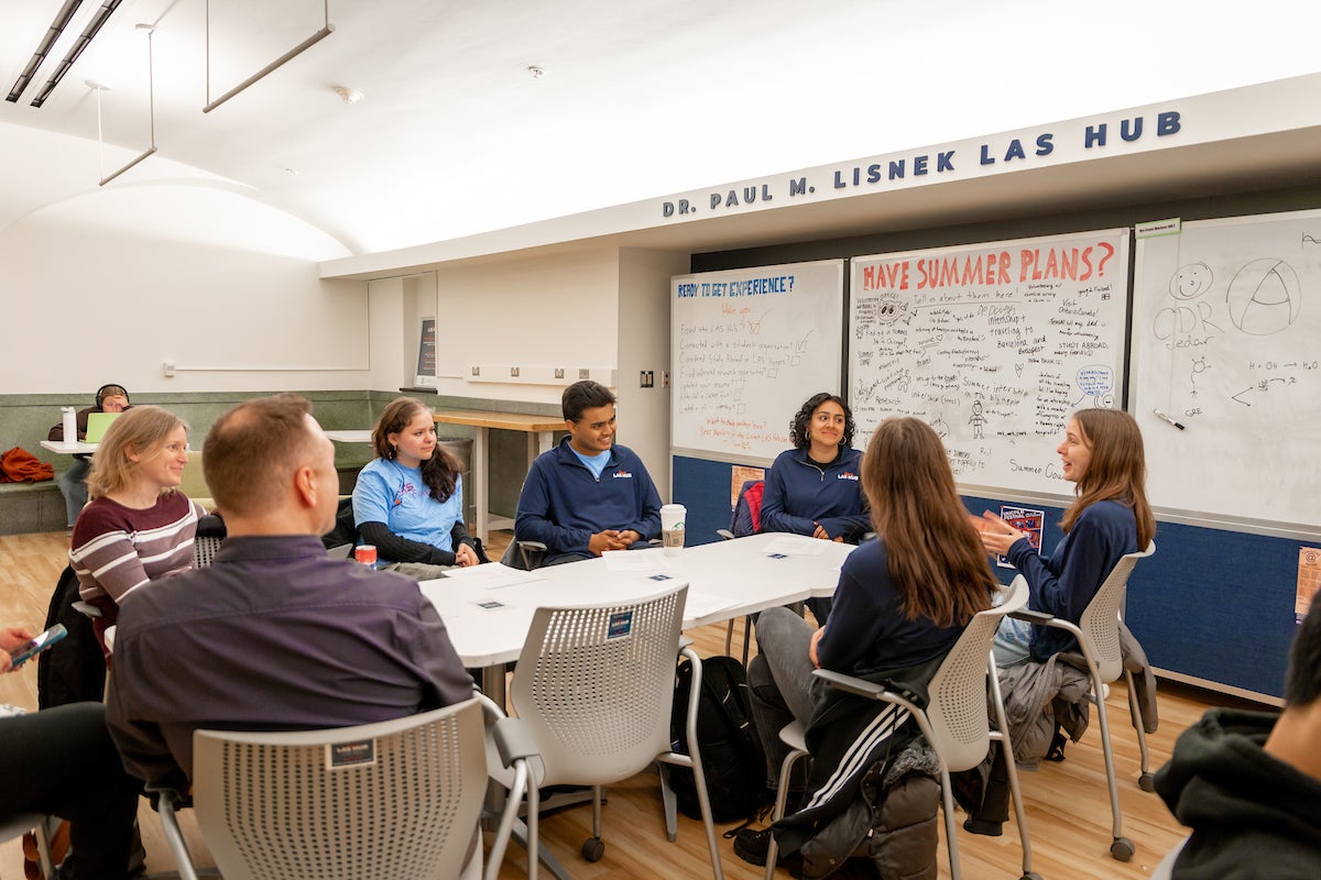 LAS Lisnek Hub peer mentors gathered at a table in the Hub, having a lively conversation