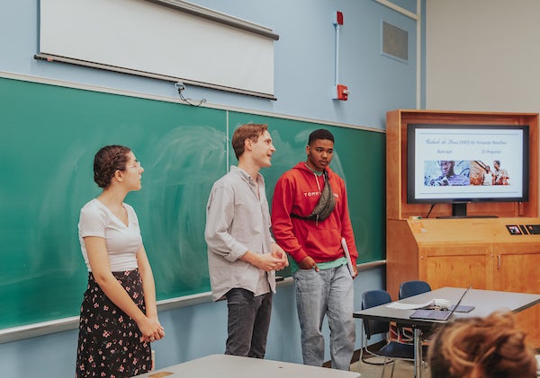 Students in the School of Literatures, Languages, Cultures, and Linguistics give a presentation in a classroom in front of a screen