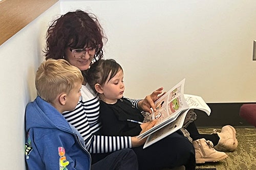 Children read with a parent at the library