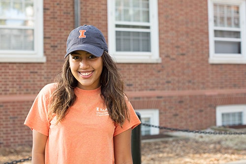 Student poses for photo in blue and orange Illinois hat