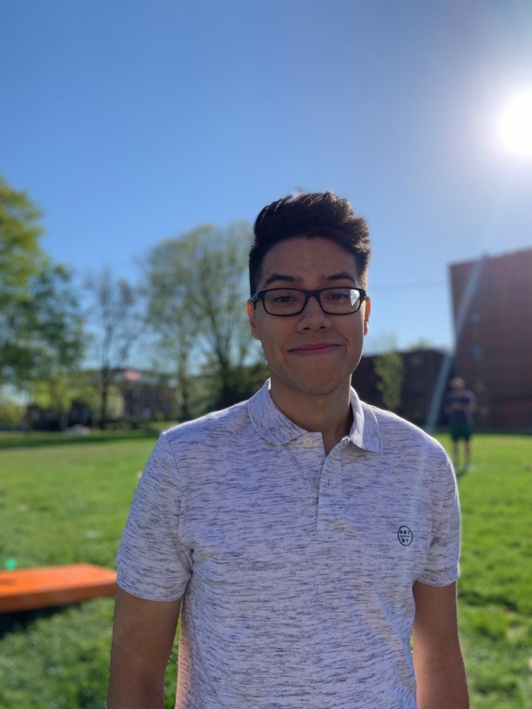 LAS student poses for photo in front of an expanse of green grass