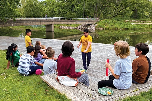 Children listening to an instructor outside