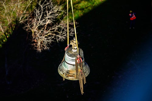 A bell hangs from a crane