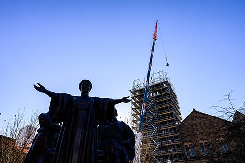 A bell hangs behind Alma Mater