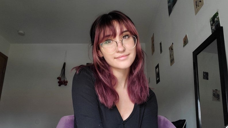 LAS student poses for a photo with glasses in her dorm room