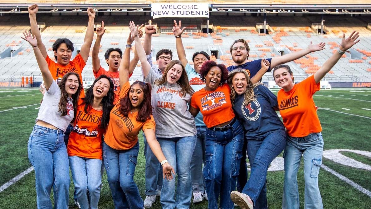 students standing in the middle of Memorial Stadium in Illini gear