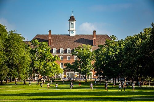 view across the green grass and trees of the Quad to the Illini Union