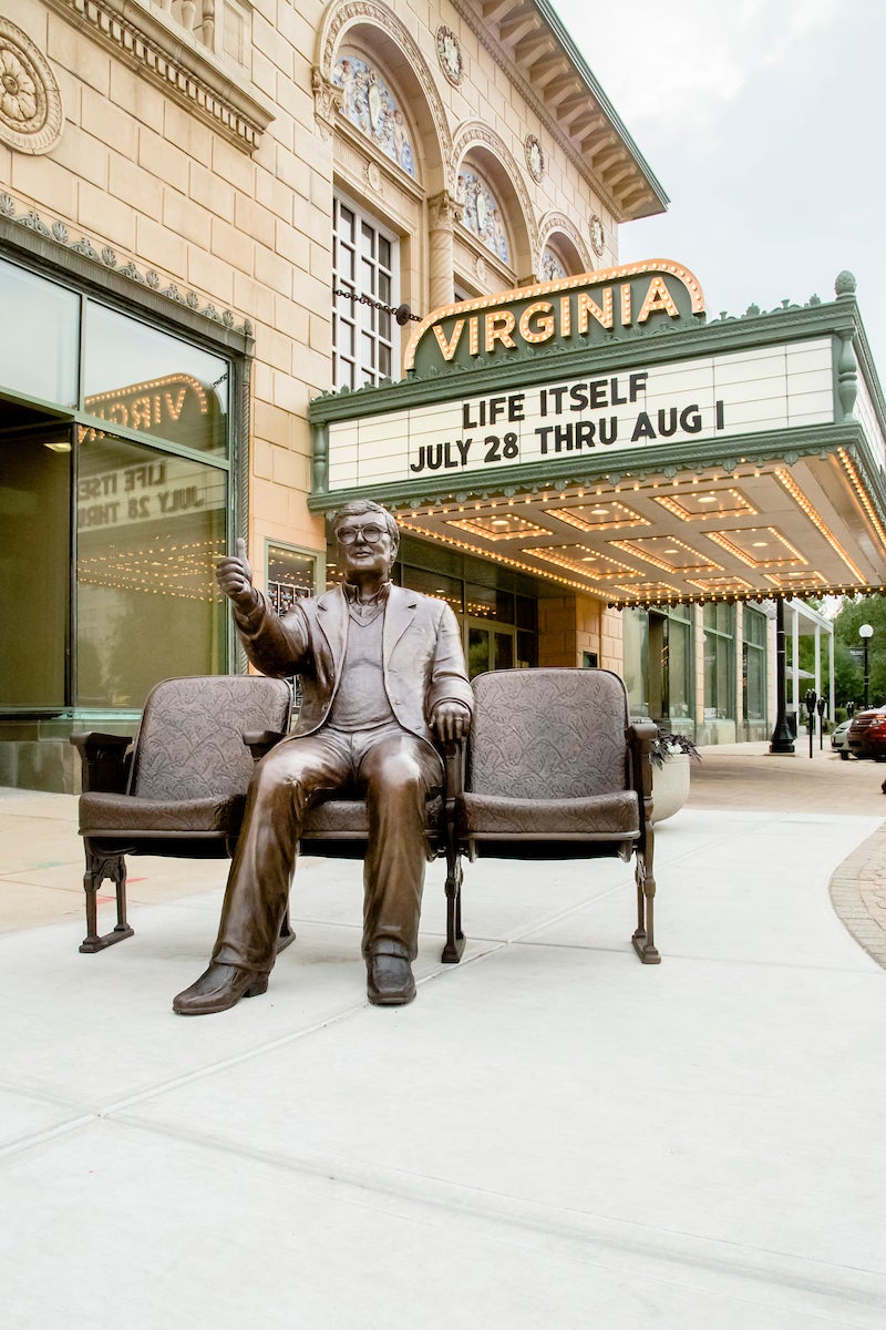 Roger Ebert statue in front of Virginia Theatre, downtown Champaign, Ill. Under "Life Itself" on marquee.