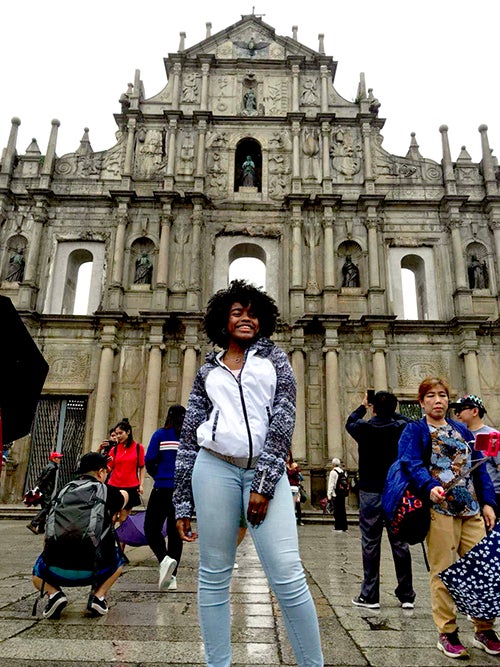 Shontierra Anderson poses outside a building in China