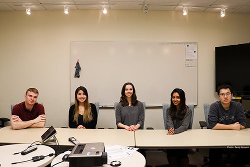 ATLAS interns smile at a table during a workshop