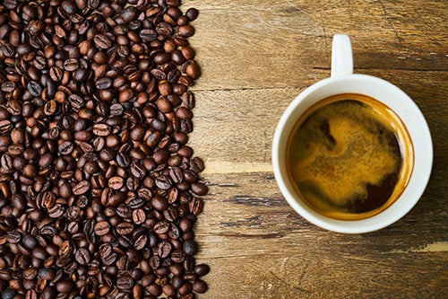 Coffee beans and a cup of coffee on a table