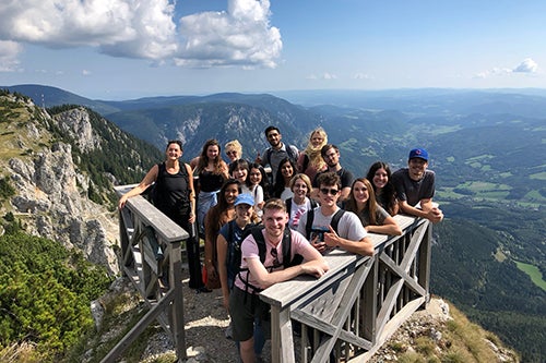 A group of students studying abroad in Vienna post on a mountain