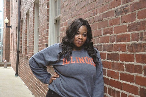 Nicole Odulate poses in front of a brick wall