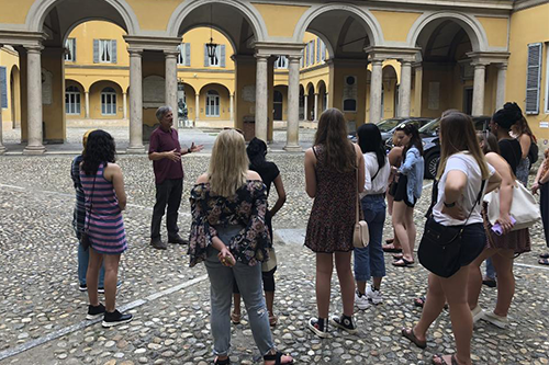 A professor leads a group of students through the streets in Pavia, Italy