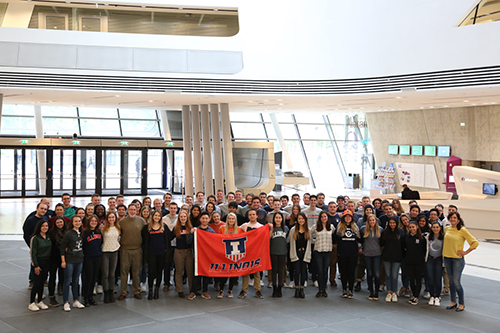 A group of students pose with an Illinois flag