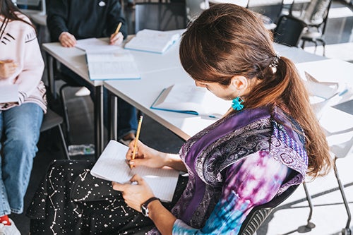 A student writing in a classroom