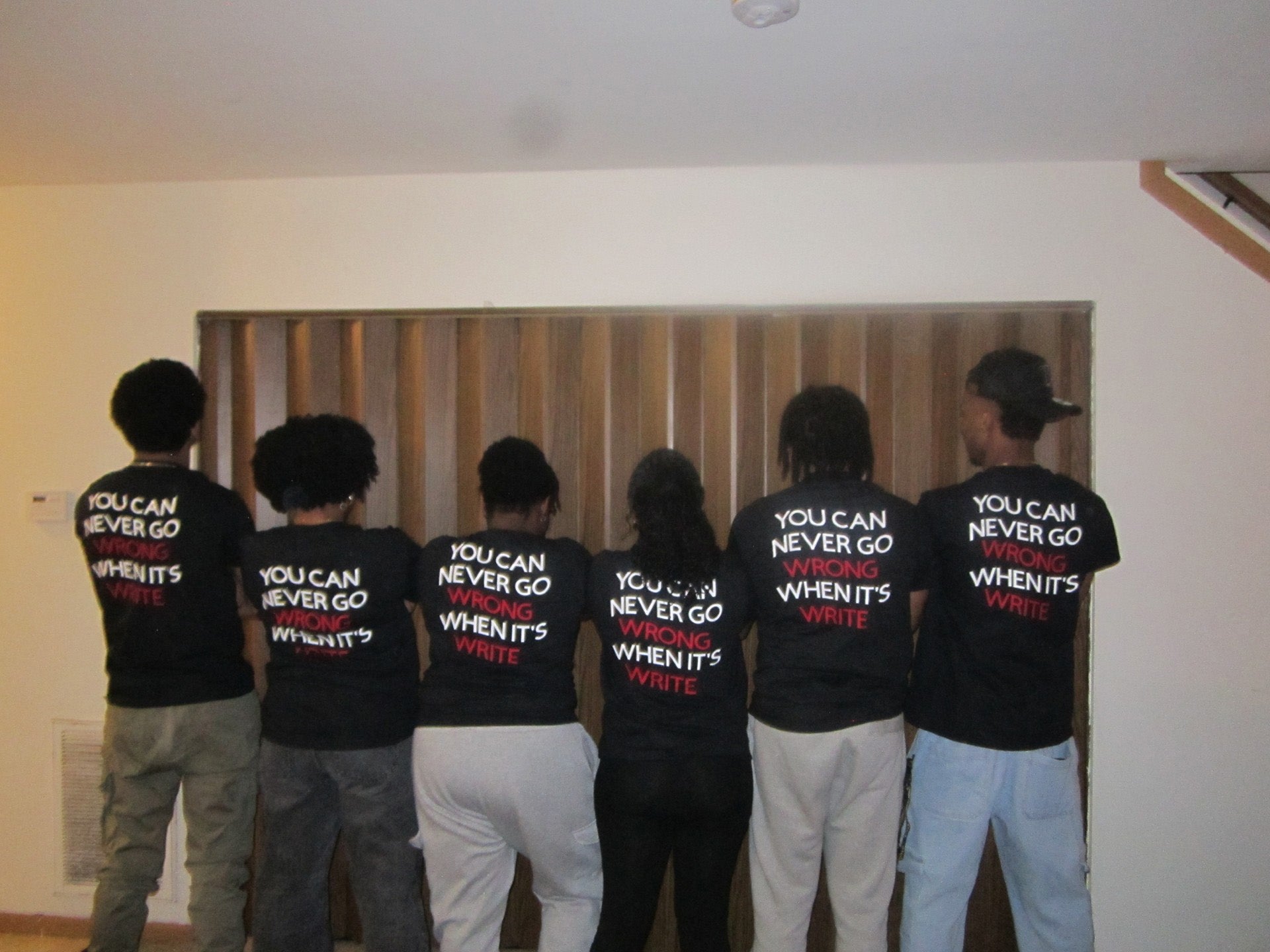 students with their backs to the camera, the back of their t-shirts reading "you can never go wrong when it's write"