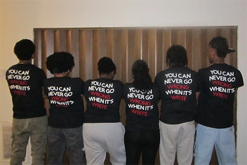 students with their backs to the camera, the back of their t-shirts reading "you can never go wrong when it's write"
