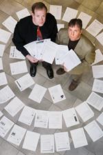 Scott Althaus, a professor of political science and of communication, right, and Kalev Leetaru, coordinator of research in the Cline Center for Democracy, show how ever-changing versions of several White House news releases have spread a distorted historical record on the Web. (Photo by L. Brian Stauffer.)