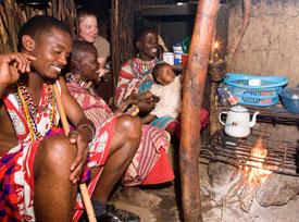 Wiszowaty's Kenyan family prepares their meals over a small fire in their home. Wiszowaty is in the back.