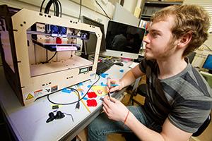Sophomore Jason Hempstead uses a 3-D printer in the Illinois Geometry Lab to make solid shapes from plastic. (Photo by L. Brian Stauffer)