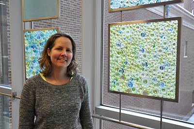 Holly Wolf-Mattick (MFA '02), of Woodstock, Ill., stands near a small portion of her exhibit, 'Circular Reflections: Geometry and Light,' in the Dean's Suite of Lincoln Hall. Her work is also part of the state Art-in-Architecture Program.