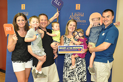 Family Friendly: Alumni and their family members of all ages ensured that the College of LAS Night at the Museum event was a lively occasion at the Peoria (Ill.) Riverfront Museum in July. From left, Corrie, Lucas, Mike, and Jake Taylor pose for a photo with Stephanie, Sawyer, Quinn, and Donnie Nommensen.