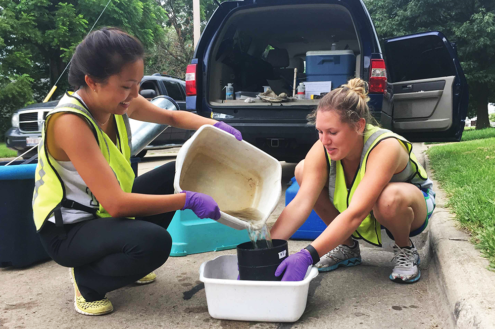 Integrative biology majors Hei Chan, left, and Madison Moore sampled water from catch basins in Champaign-Urbana for a study of mosquito reproduction. (Photo courtesy of Hei Chan.) 