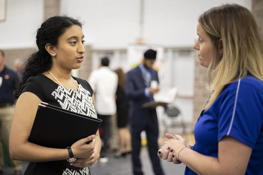 Neha Akella, left, a senior in biochemistry, spoke with a potential employer at the ACES + LAS Career Fair. (Photo by Jesse Wallace.) 