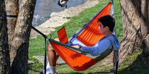 A student sits in a hammock near Boneyard Creek