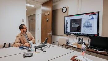 A professor connects to a Zoom meeting during a class