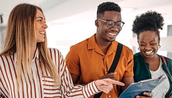 People smiling and pointing at a photo
