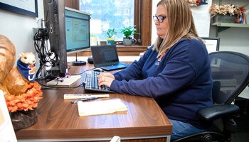 HR employee working at desk at computer. 