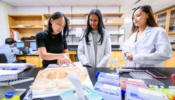 Molecular & Integrative Physiology Professor Xinzhu Yu works with research students her lab. 
