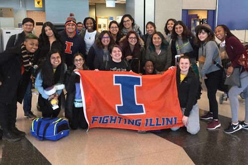 LAS students pose with an Illini flag at the airport before departing on a study abroad trip